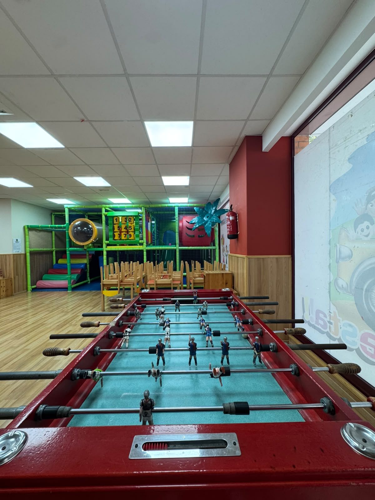 Futbolí gran a la sala, amb el parc de boles al fons